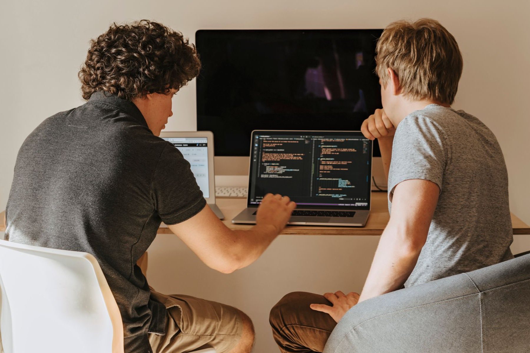 Due sviluppatori al lavoro sul codice del software davanti a un portatile